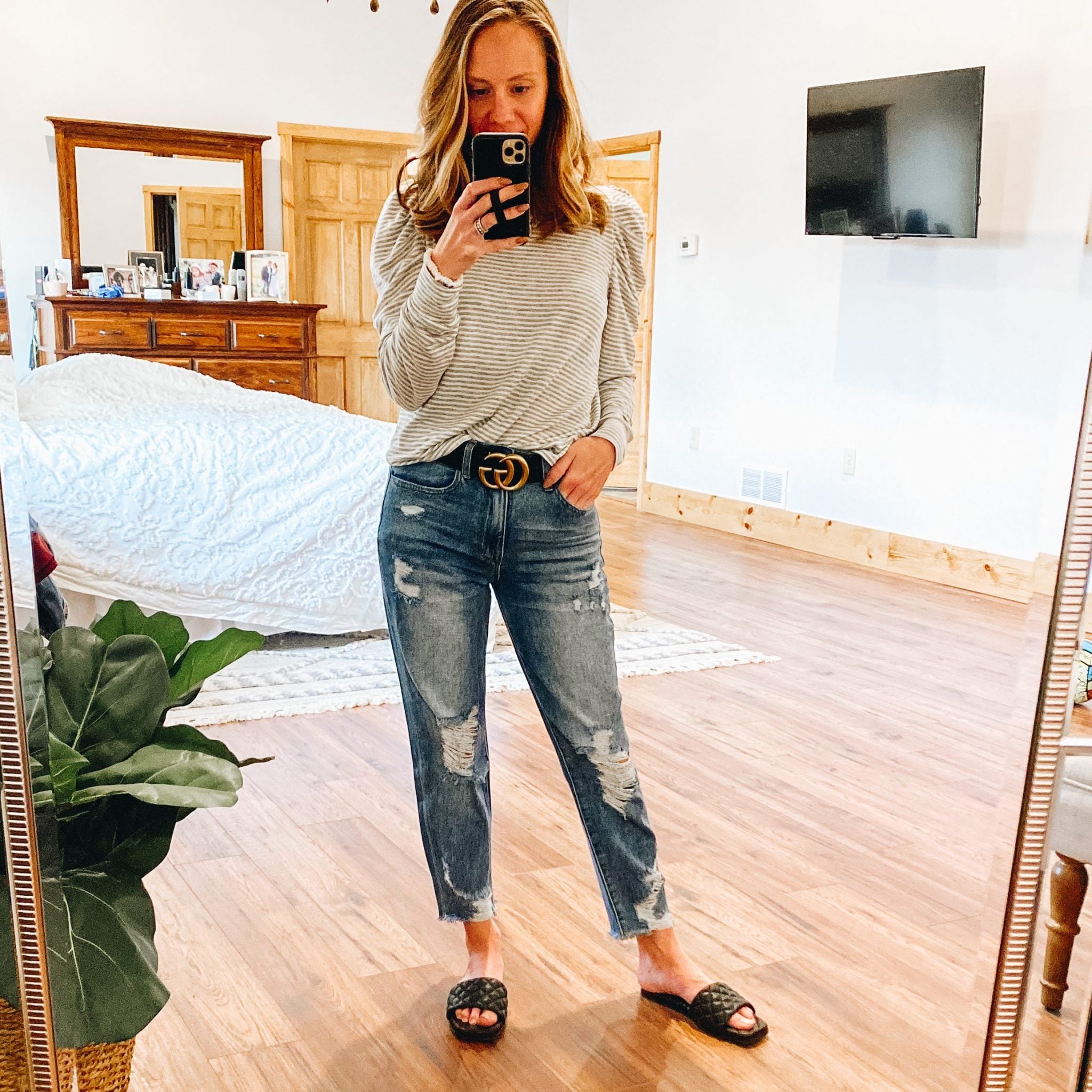 Top 7 Cute Spring Sandals for Women featured by top Pittsburgh fashion blogger, Fashionably Late Mom. |Spring Sandals by popular Pittsburgh fashion blog, Fashionably Late Mom: image of a woman wearing a black and white stripe puff sleeve top, deconstructed denim, and black slide sandals. 