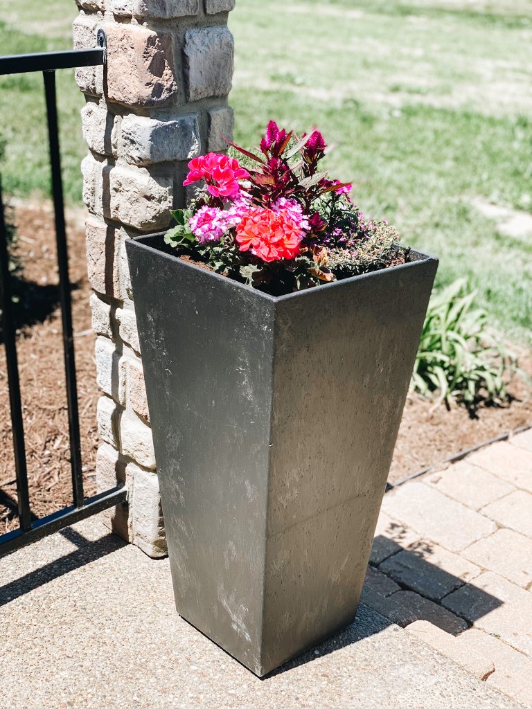 flower planter, geraniums |  Summer Front Porch by popular Pittsburg life and style blog, Fashionably Late Mom: image of tall black planters iwht pink and red flowers. 