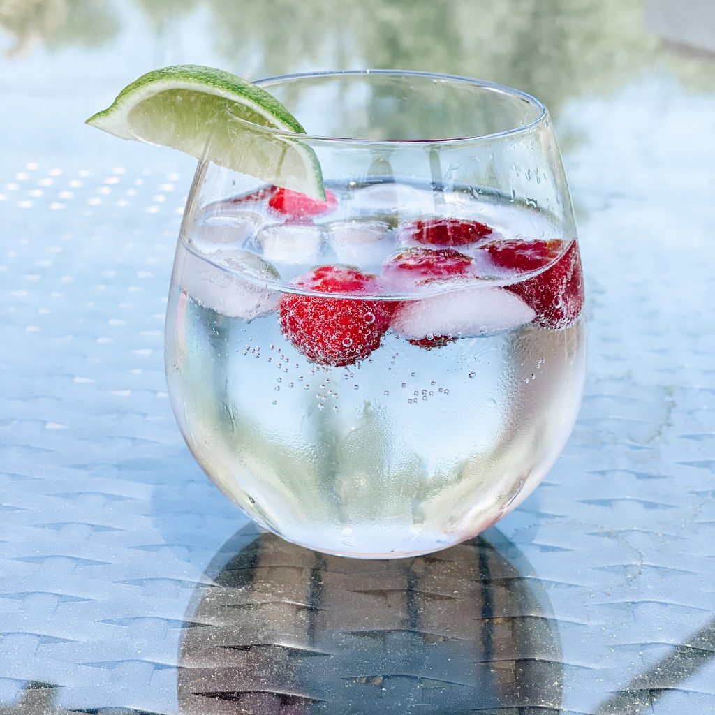 raspberry summer spritzer | Raspberry Spritzer by popular Pittsburg lifestyle blog, Fashionably Late: image of a raspberry spritzer in stemless glass with a lime wedge garnish. 