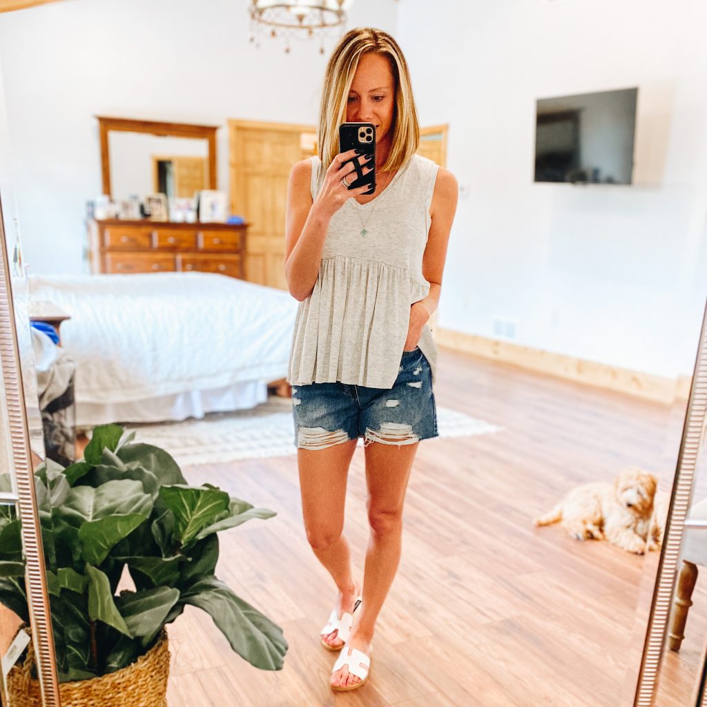 Pink Lily Boutique Favorites for Spring and Summer featured by top Pittsburgh fashion blogger, Fashionably Late Mom |  Pink Lily Boutique by popular Pittsburg fashion blog, Fashionably Late Mom: image of a woman wearing a Pink Lily Boutique grey peplum tank, deconstructed jean shorts and white strap slide sandals. 