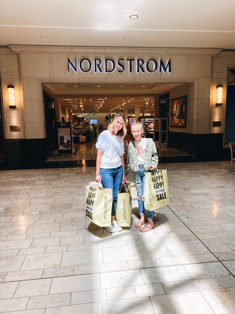 Nordstrom Anniversary Sale 2021: Try On Edition featured by top Pittsburgh fashion blogger, Fashionably Late Mom | Nordstrom Anniversary Sale by popular Pittsburgh fashion blog, Fashionably Late Mom: image of a woman and her teenage daughter standing outside a Nordstrom department store and holding Nordstrom Anniversary Sale shopping bags. 