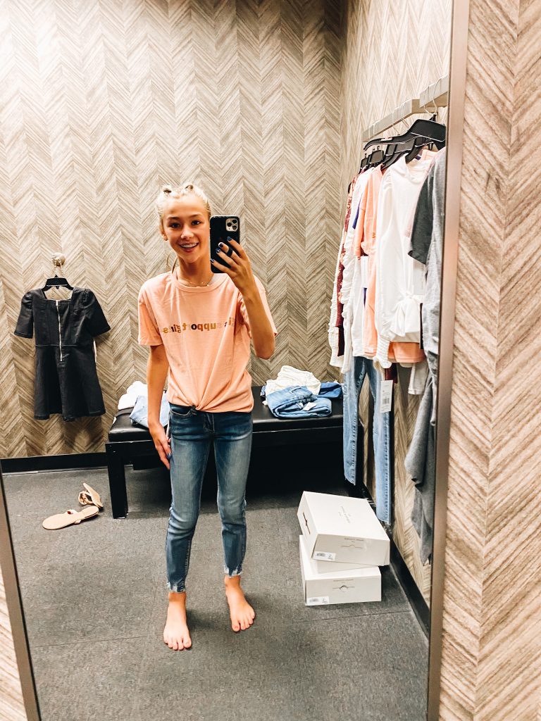Nordstrom Anniversary Sale 2021: Try On Edition featured by top Pittsburgh fashion blogger, Fashionably Late Mom | Nordstrom Anniversary Sale by popular Pittsburgh fashion blog, Fashionably Late Mom: image of a teenage girl wearing a Nordstrom peach colored graphic t-shirt and jeans. 