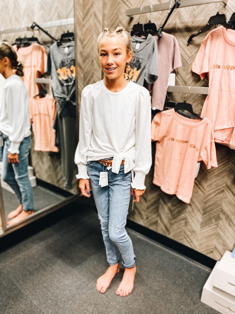 Nordstrom Anniversary Sale 2021: Try On Edition featured by top Pittsburgh fashion blogger, Fashionably Late Mom | Nordstrom Anniversary Sale by popular Pittsburgh fashion blog, Fashionably Late Mom: image of a teenage girl wearing a Nordstrom white tie front long sleeve shirt with light wash jeans. 