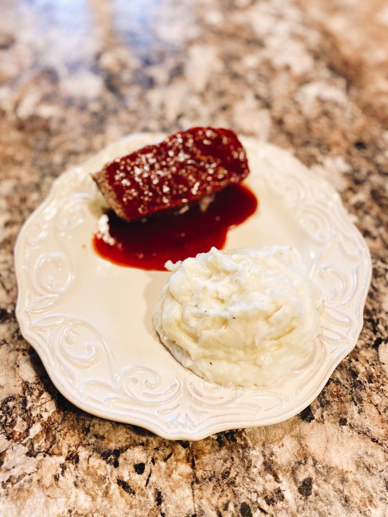 sweet and spicy meatloaf, dinner ideas, family dinner recipe, meatloaf recipe | Sweet and Spicy Meatloaf by popular Pittsburgh lifestyle blog, Fashionably Late Mom: image of a slice of meatloaf and some mashed potatoes on a white plate. 