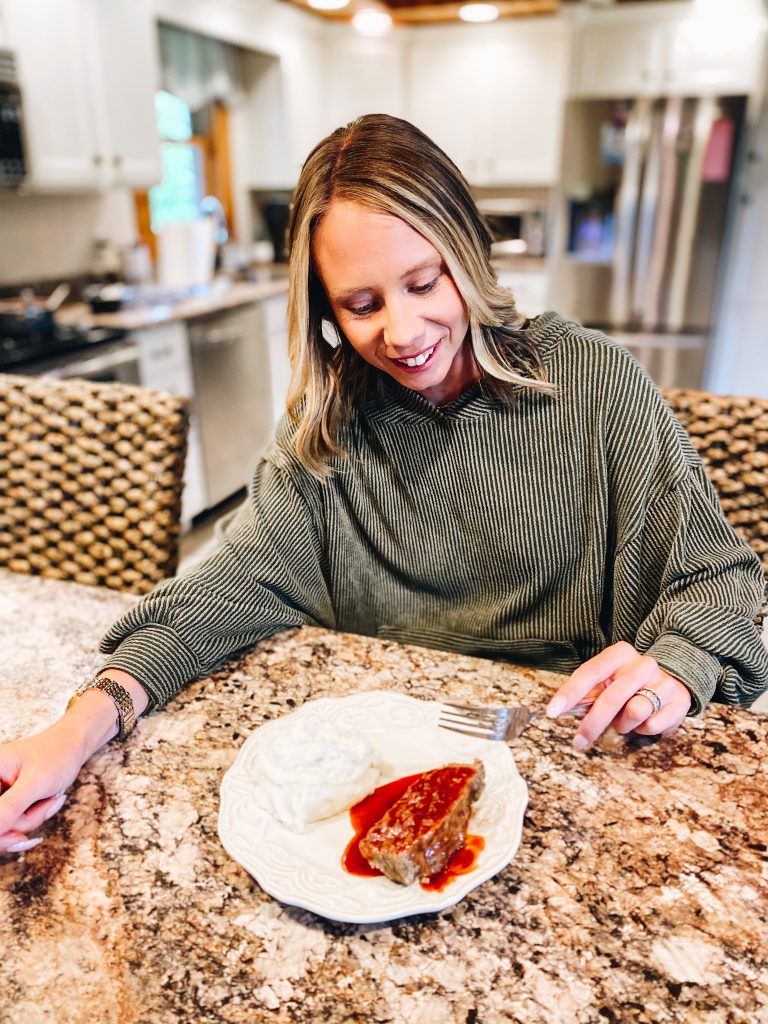 sweet and spicy meatloaf, dinner ideas, family dinner recipe, meatloaf recipe | Sweet and Spicy Meatloaf by popular Pittsburgh lifestyle blog, Fashionably Late Mom: image of a woman eating meatloaf and mashed potatoes. 