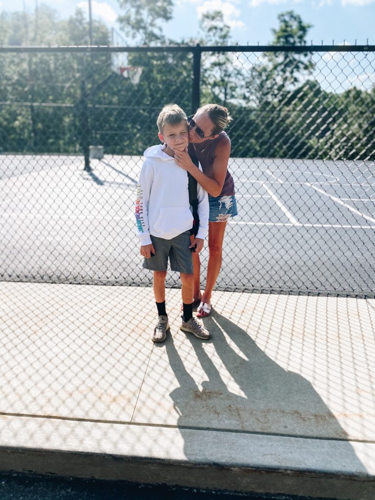 back to school fashion for boys, abercrombie kids, target for kids, boys style | Back to School Outfits by popular Pittsburgh fashion blog, Fashionably Late Mom: image of a mom kissing her son on the cheek while they stand next to an outdoor basketball court. 