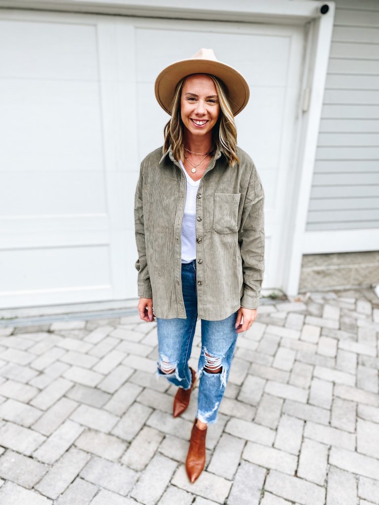 Pink Lily by popular Pittsburgh fashion blog, Fashionably Late Mom: image of a woman wearing a Pink Lilly  tan felt fedora hat, grey shacket, distressed jeans, brown ankle boots, and white graphic t-shirt. 