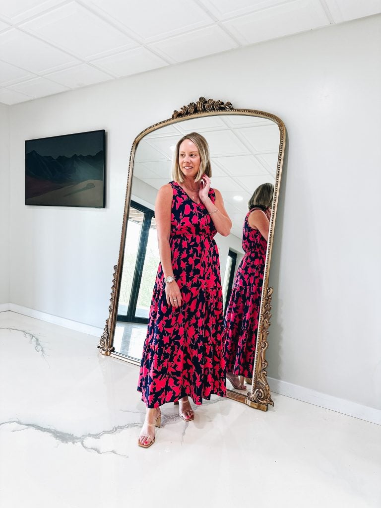 Woman wearing a pink and navy blue floral patterned maxi dress.