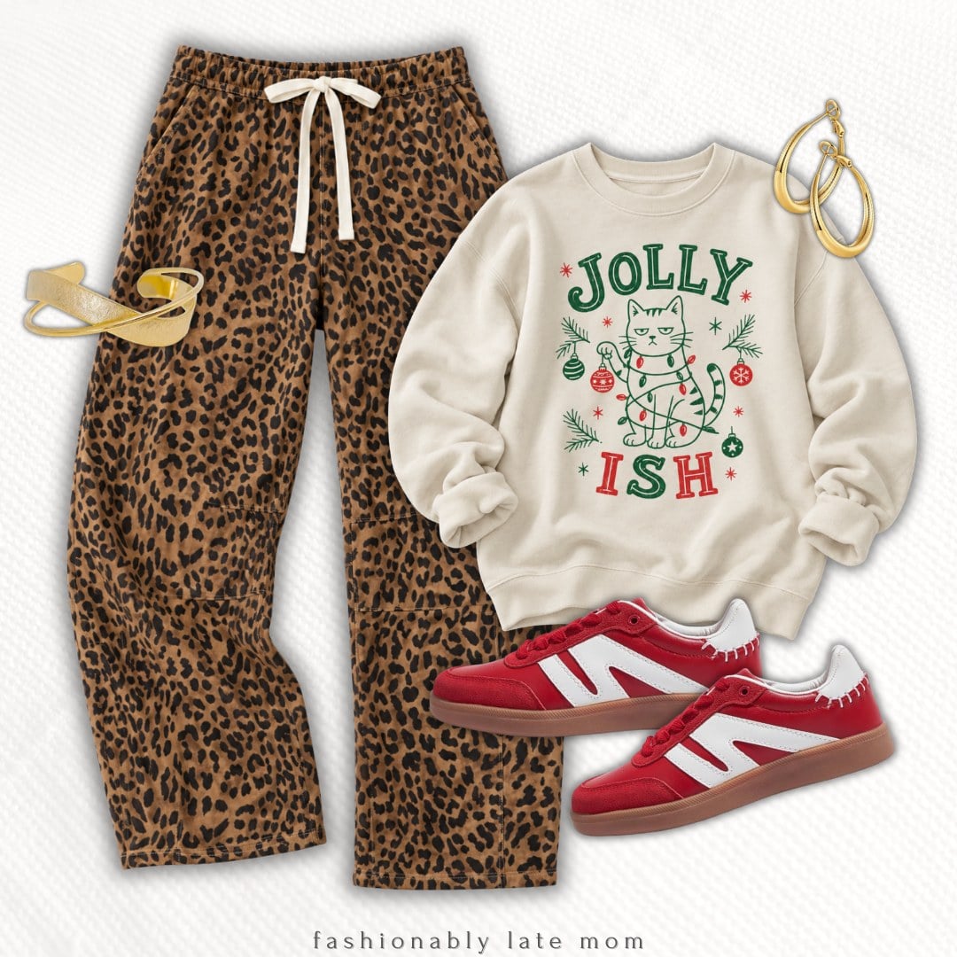 Cozy Christmas outfit with leopard print pajama pants, a cream Jolly Ish cat graphic sweatshirt, red and white sneakers and gold hoop earrings